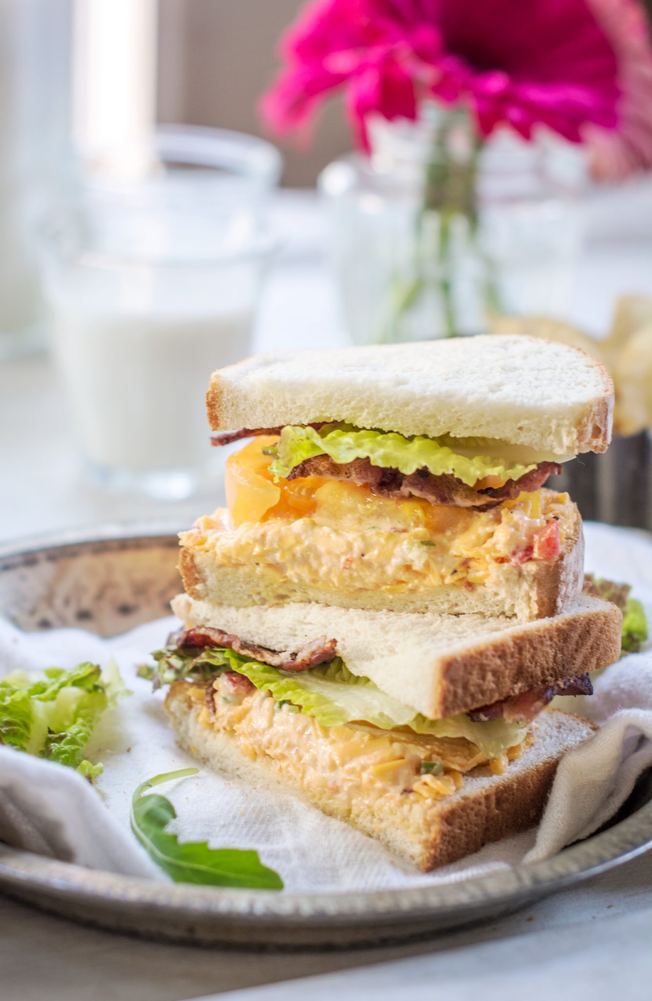 A stacked sandwich on Pepperidge Farm hearty white bread with pimiento cheese, bacon, lettuce and tomatoes.