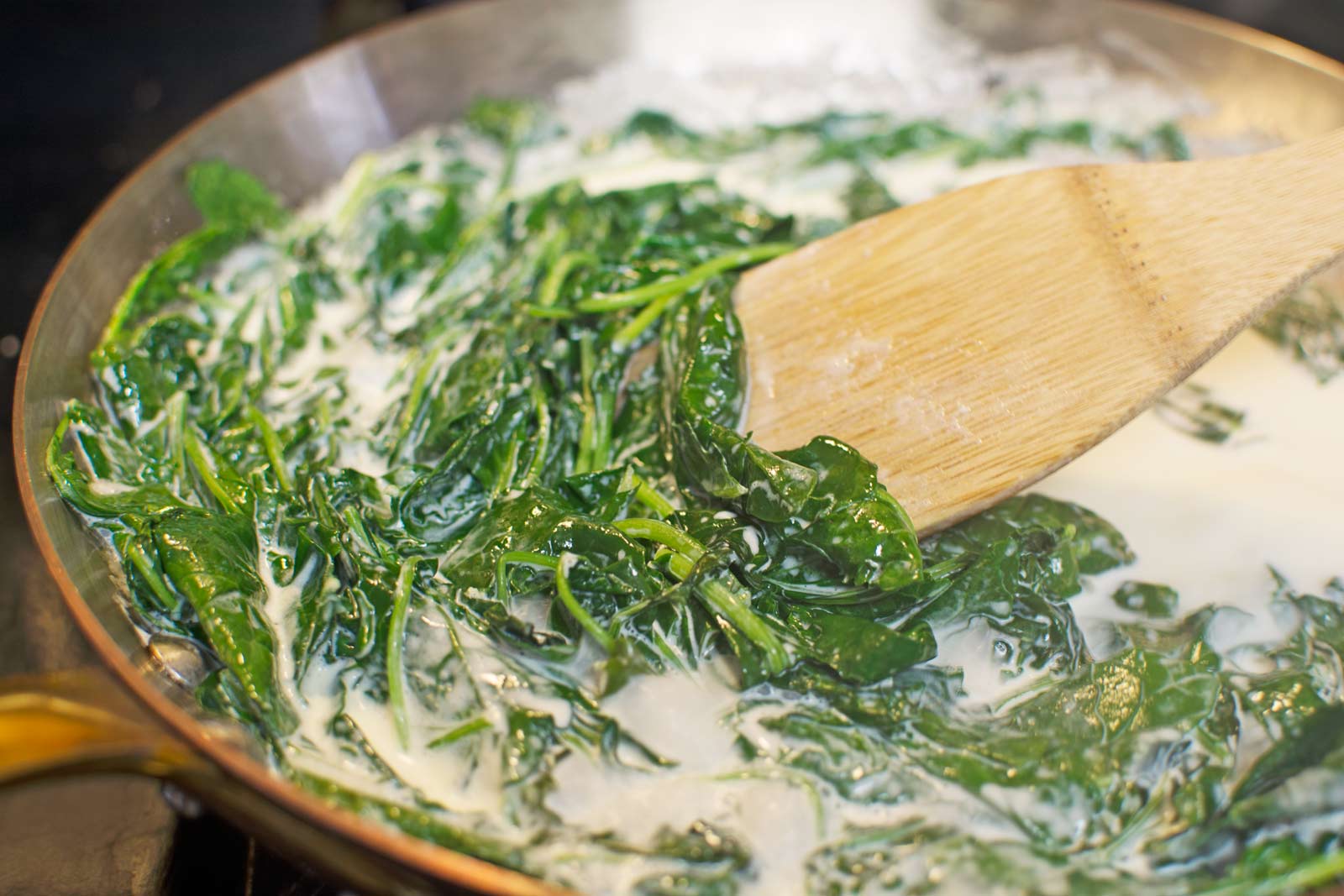 Incredibly yummy baby Kale cooking in cream - Find out more how to make Baked Eggs in this oh so Creamy Kale @LittleFiggyFood 