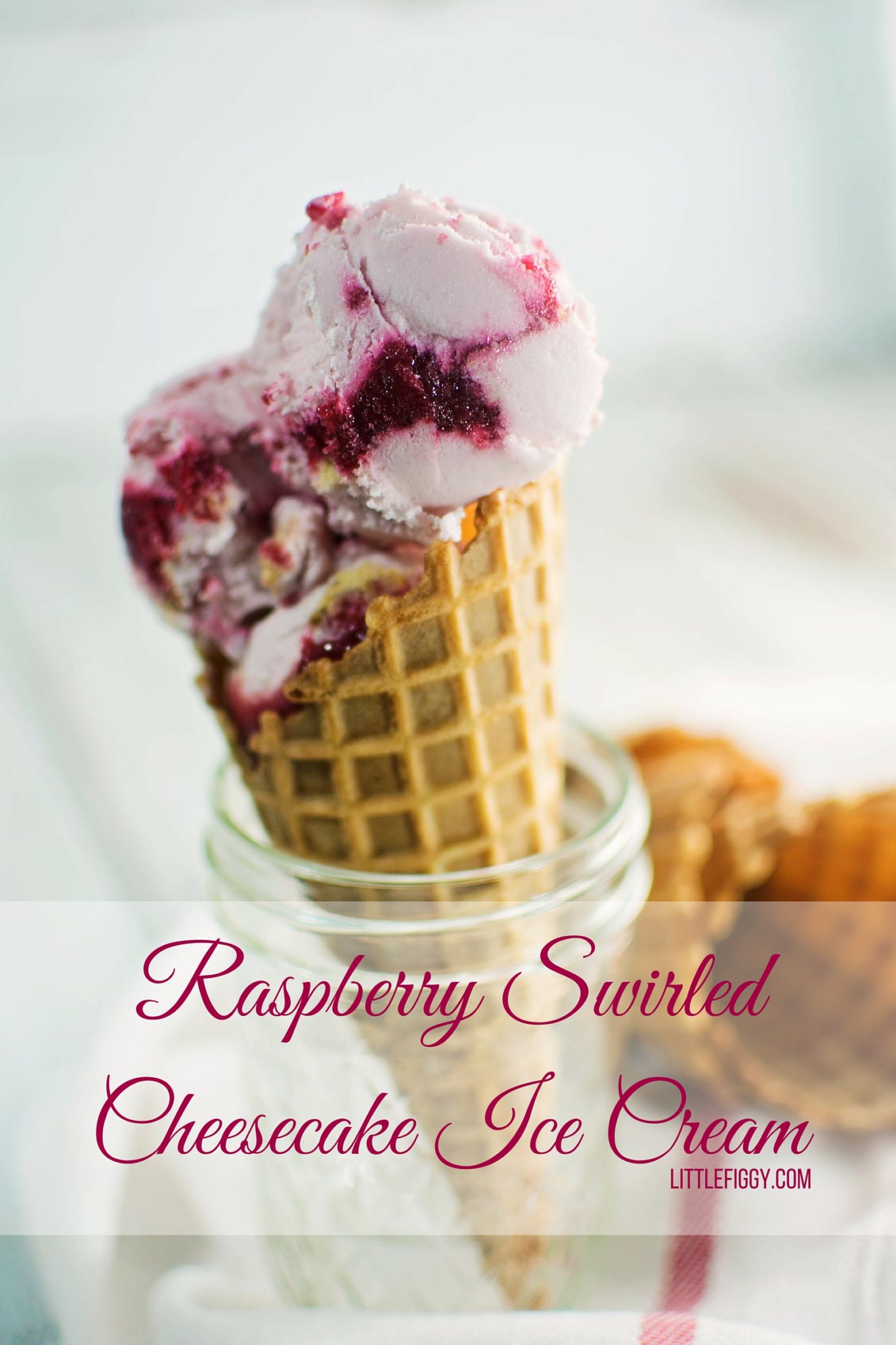Homemade raspberry ripple cheesecake ice cream in a waffle cone