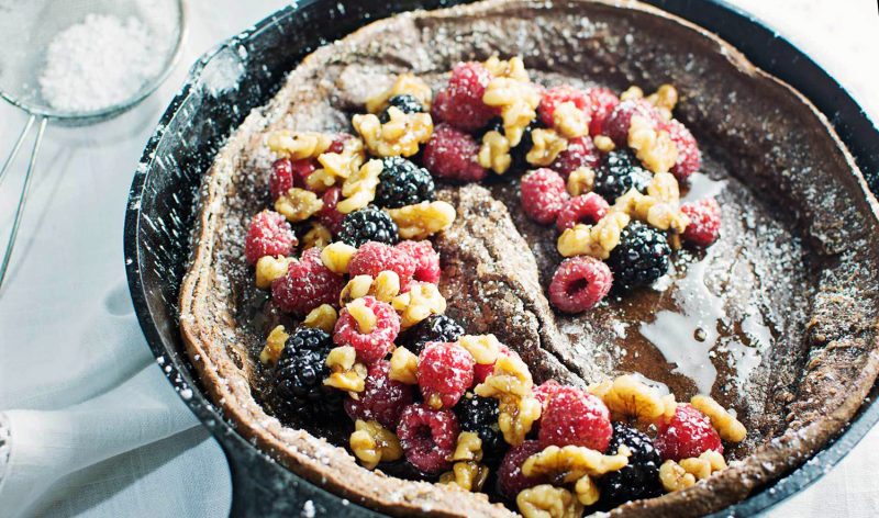 Enjoy a decadent breakfast or dessert with this Chocolate Dutch Baby served with fresh fruit and drizzles of warmed maple syrup and toasted walnuts! Get the recipe at LittleFiggyFood
