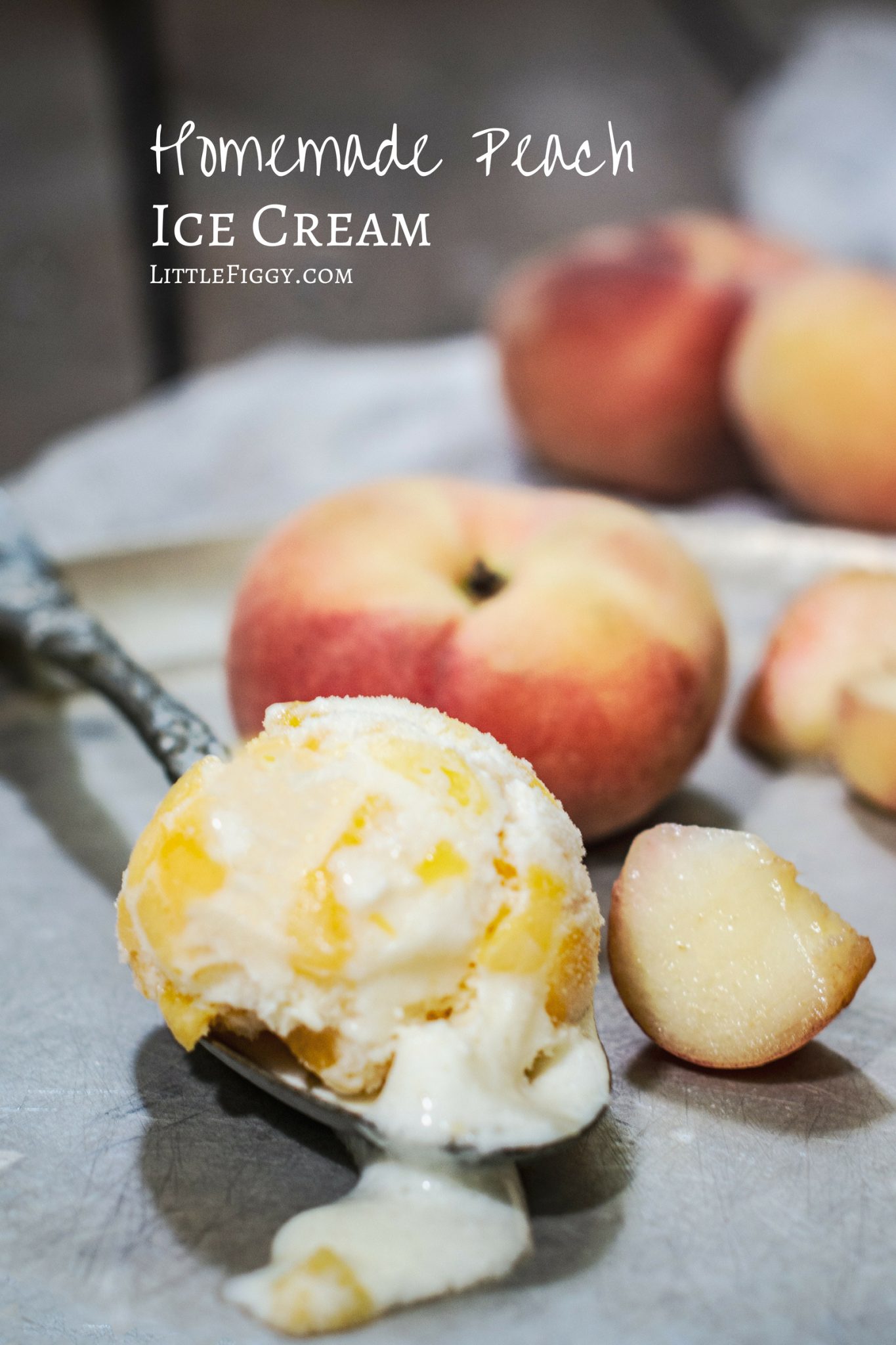 A scoop of homemade peach ice cream on a silver plate with sliced fresh peaches.