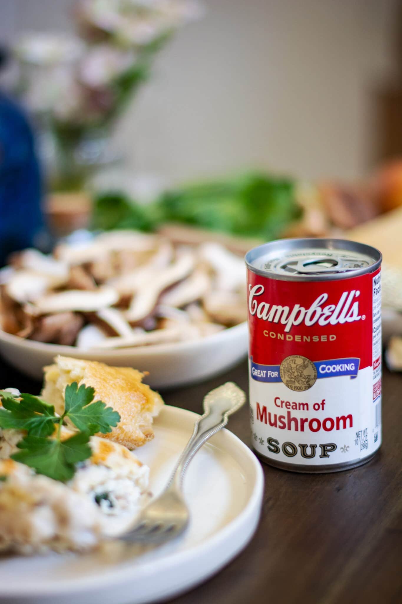 Manicotti on white plate with a can of Campbells Cream of Mushroom Soup on wood table