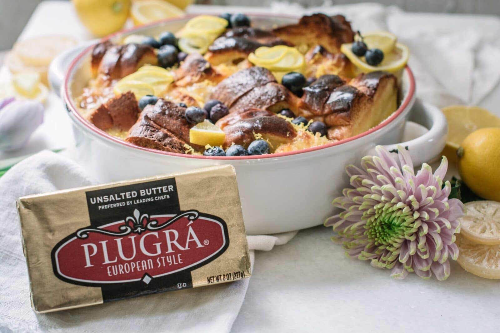 Plugra unsalted butter on white table with brioche bread pudding