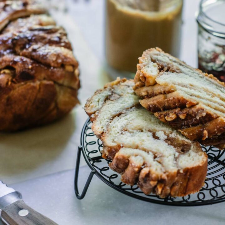 Cut swirled peanut butter and jelly babka bread on white table