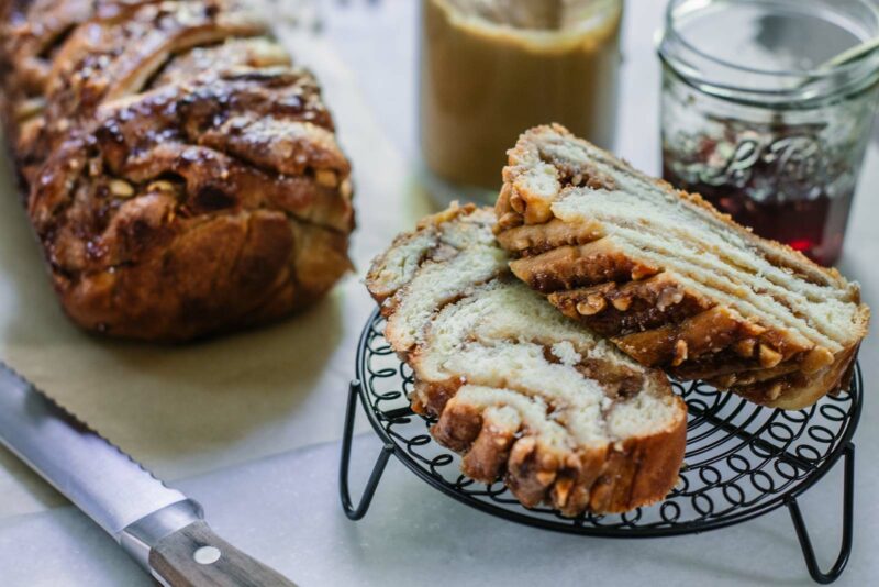 Cut swirled peanut butter and jelly babka bread on white table