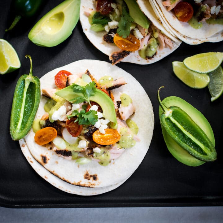 Fish tacos served with avocado, salsa, and jalapenos