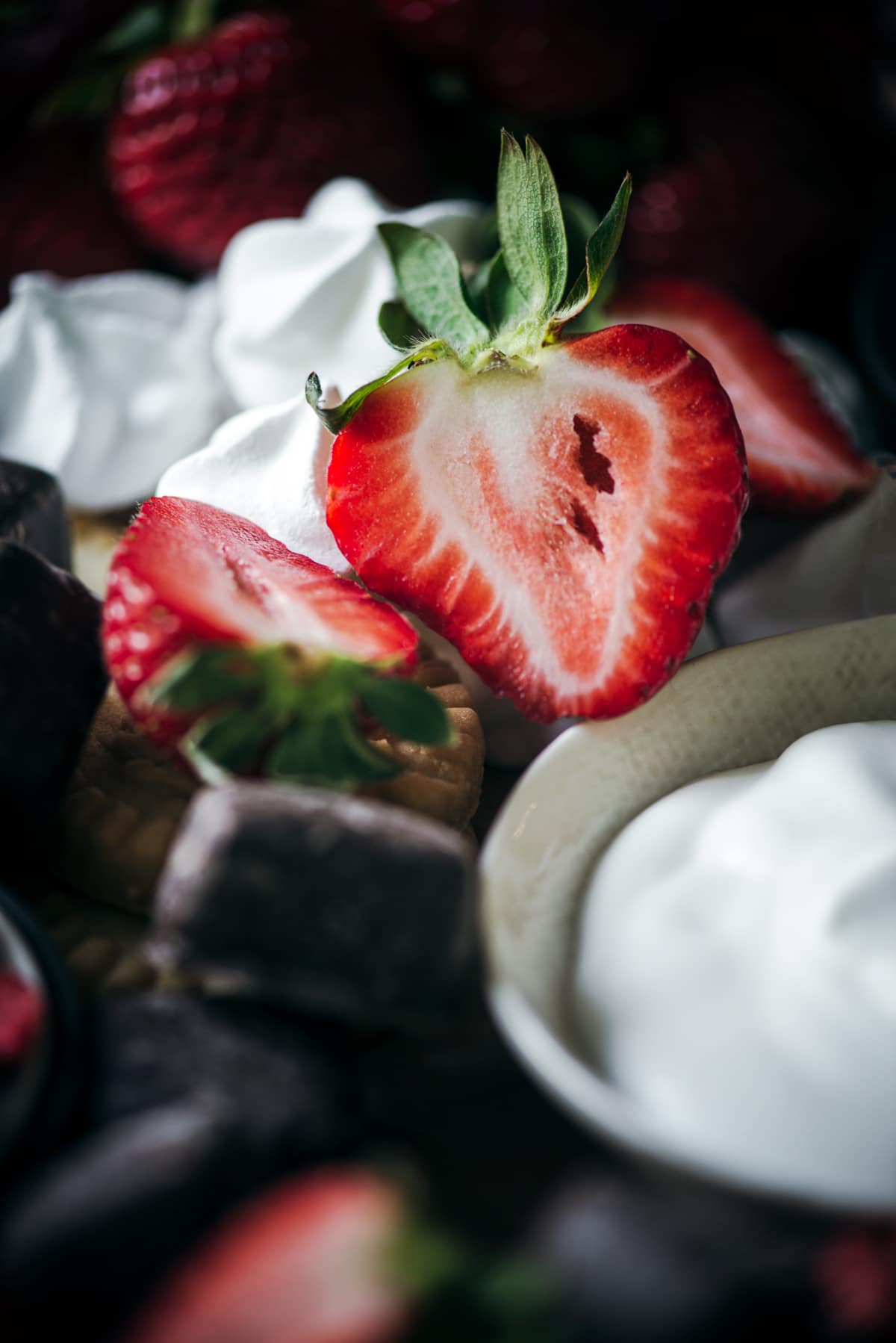Halved fresh strawberries on dessert board