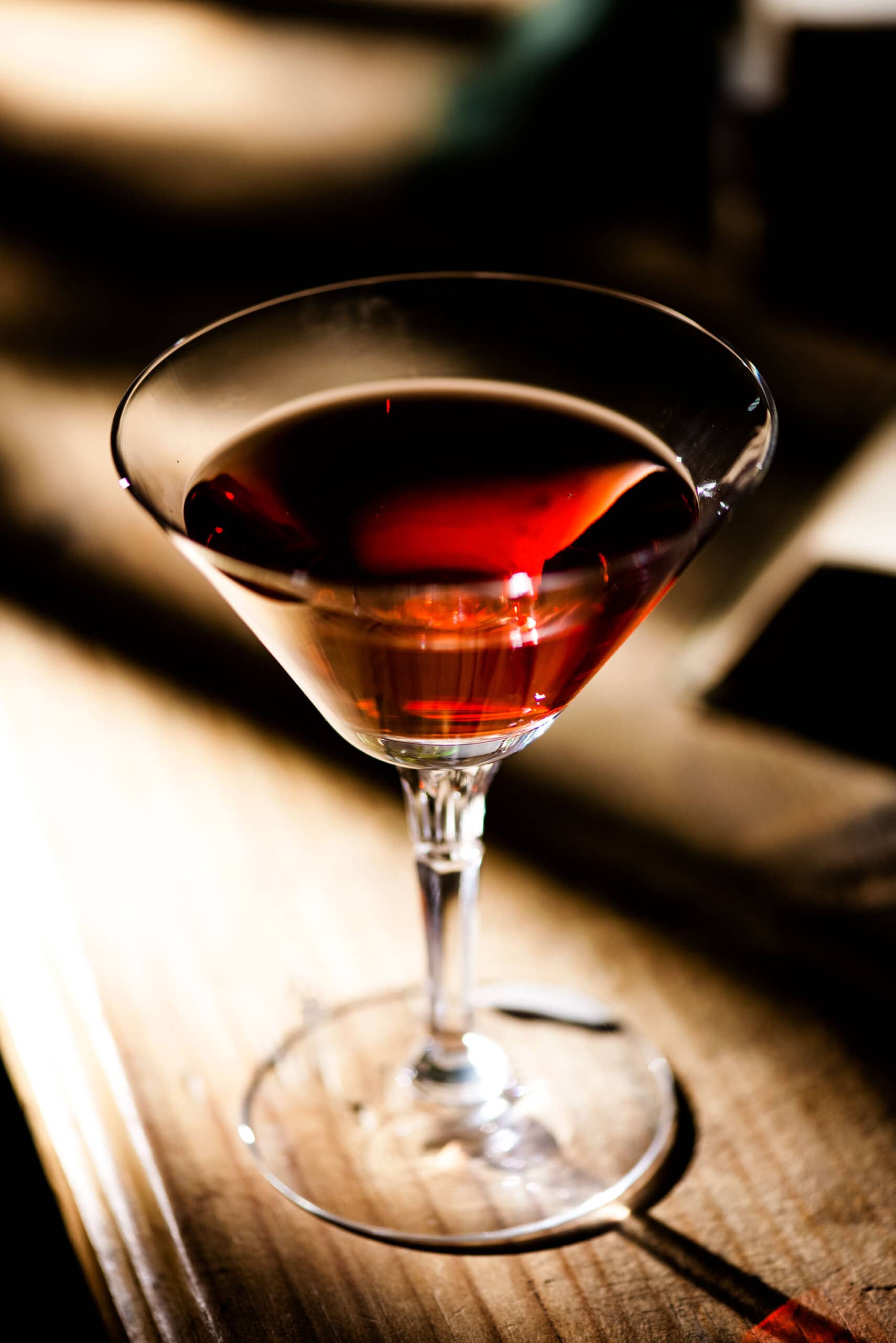 Single glass with red drink on a wooden table