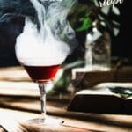 Drink in glass with smoke on wooden table